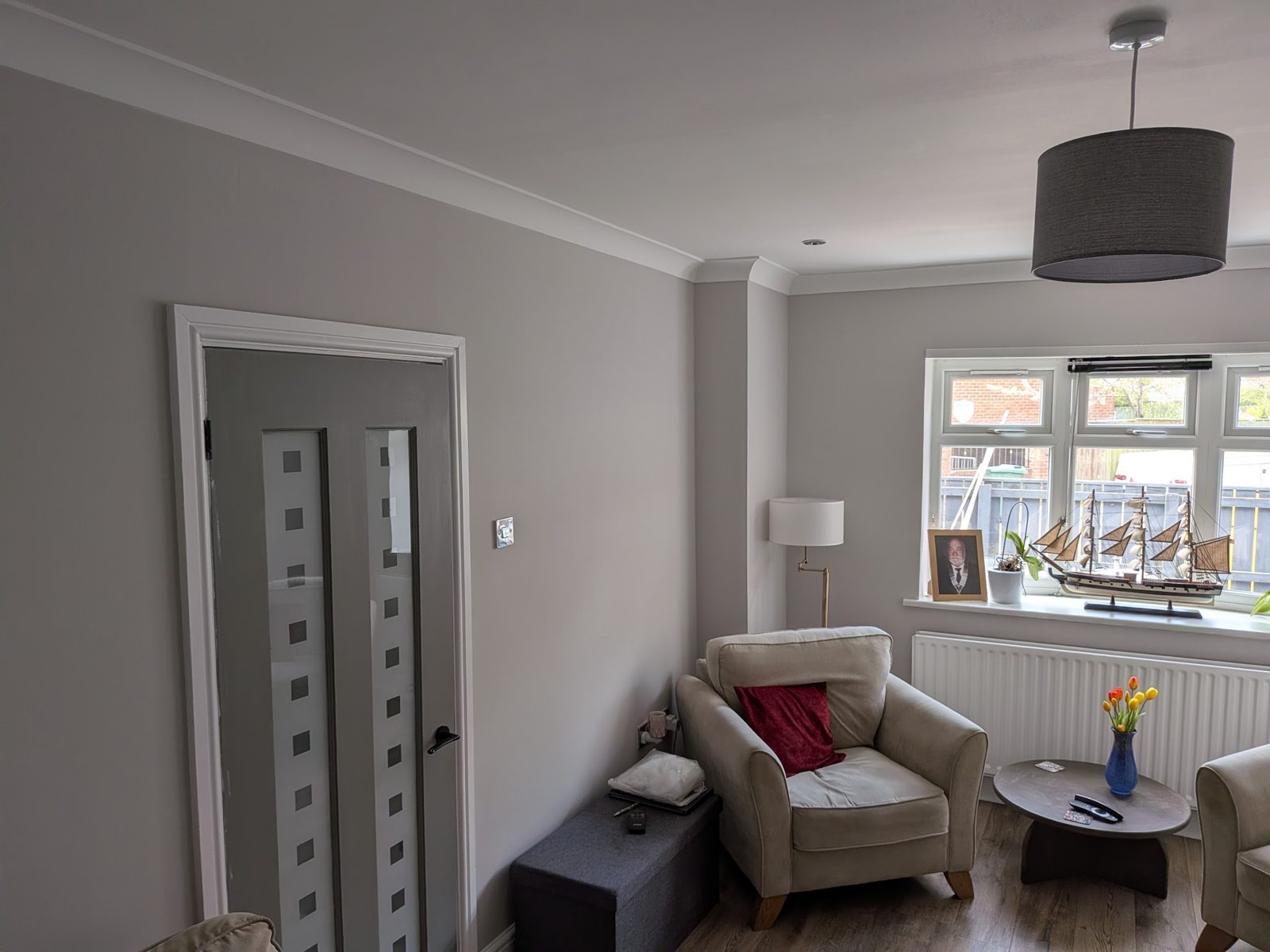 A finished lounge painted warm grey with white coving and doors